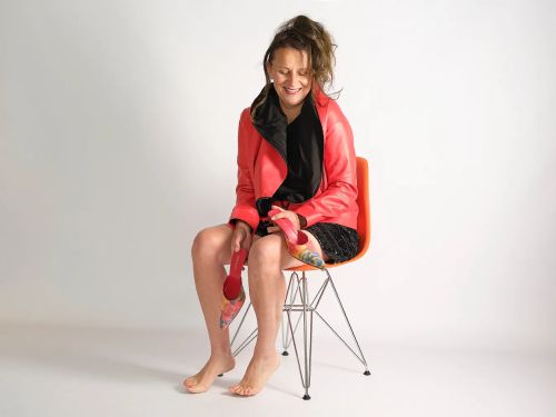 Christine Hartge sitzt in roter Lederjacke auf einem orangen Stuhl